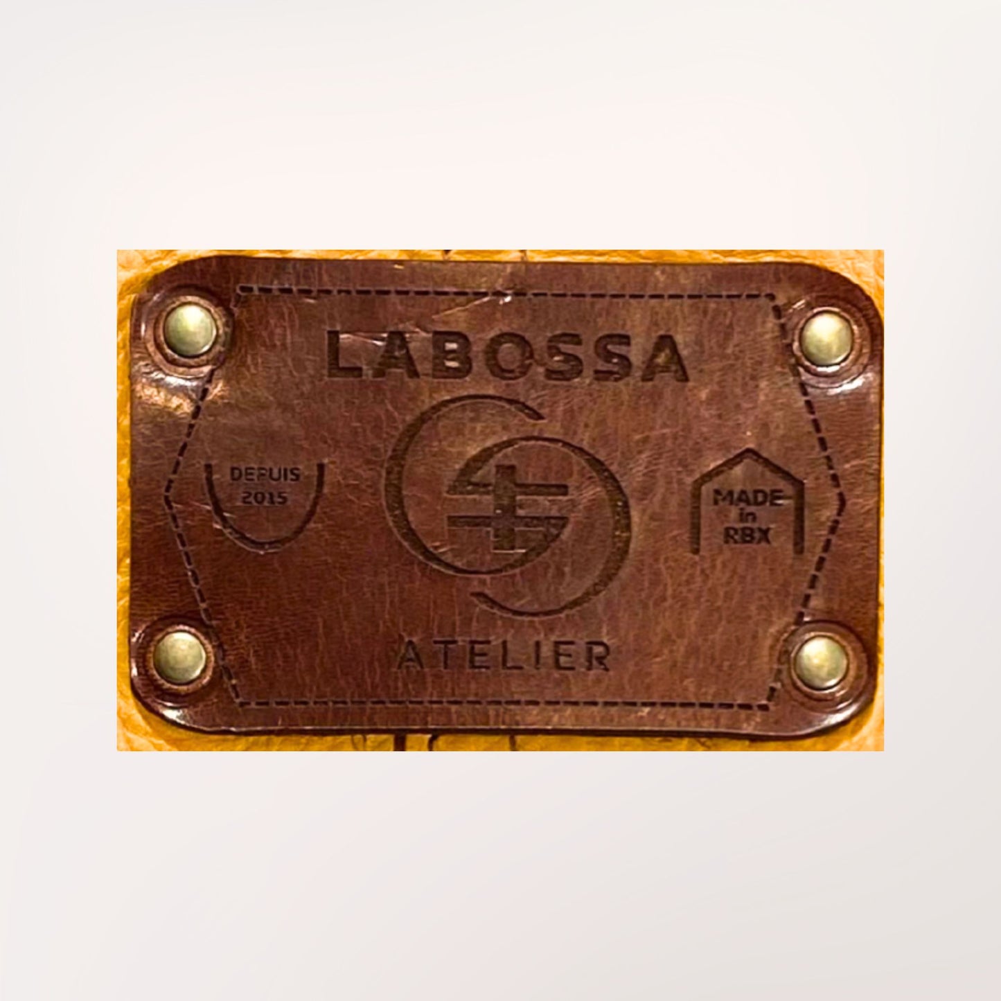 Détail extérieur patch cuir gravé du cabas cuir moutarde et chocolat — Labossa Atelier Roubaix
