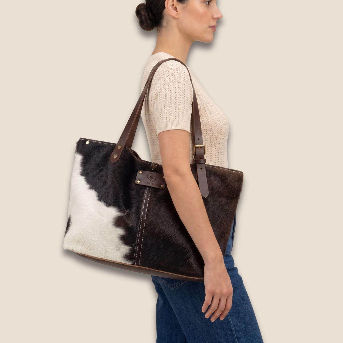 Cabas Salers #27/160 porté à l’épaule, avec sa robe brun profond et blanc et ses lanières en cuir marron.