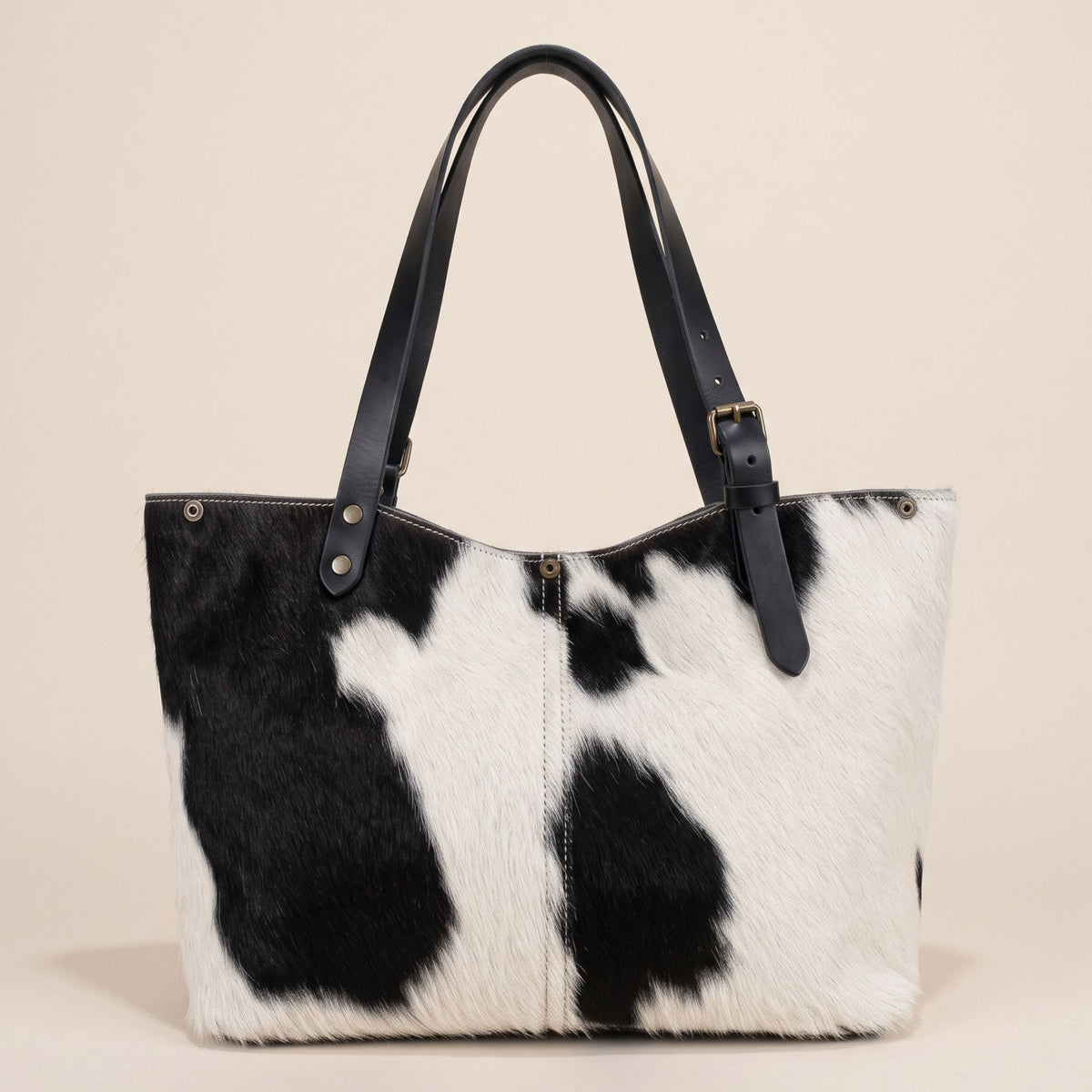 Dos du cabas en peau de vache Holstein #27/163, avec taches noires sur fond blanc et couture centrale.