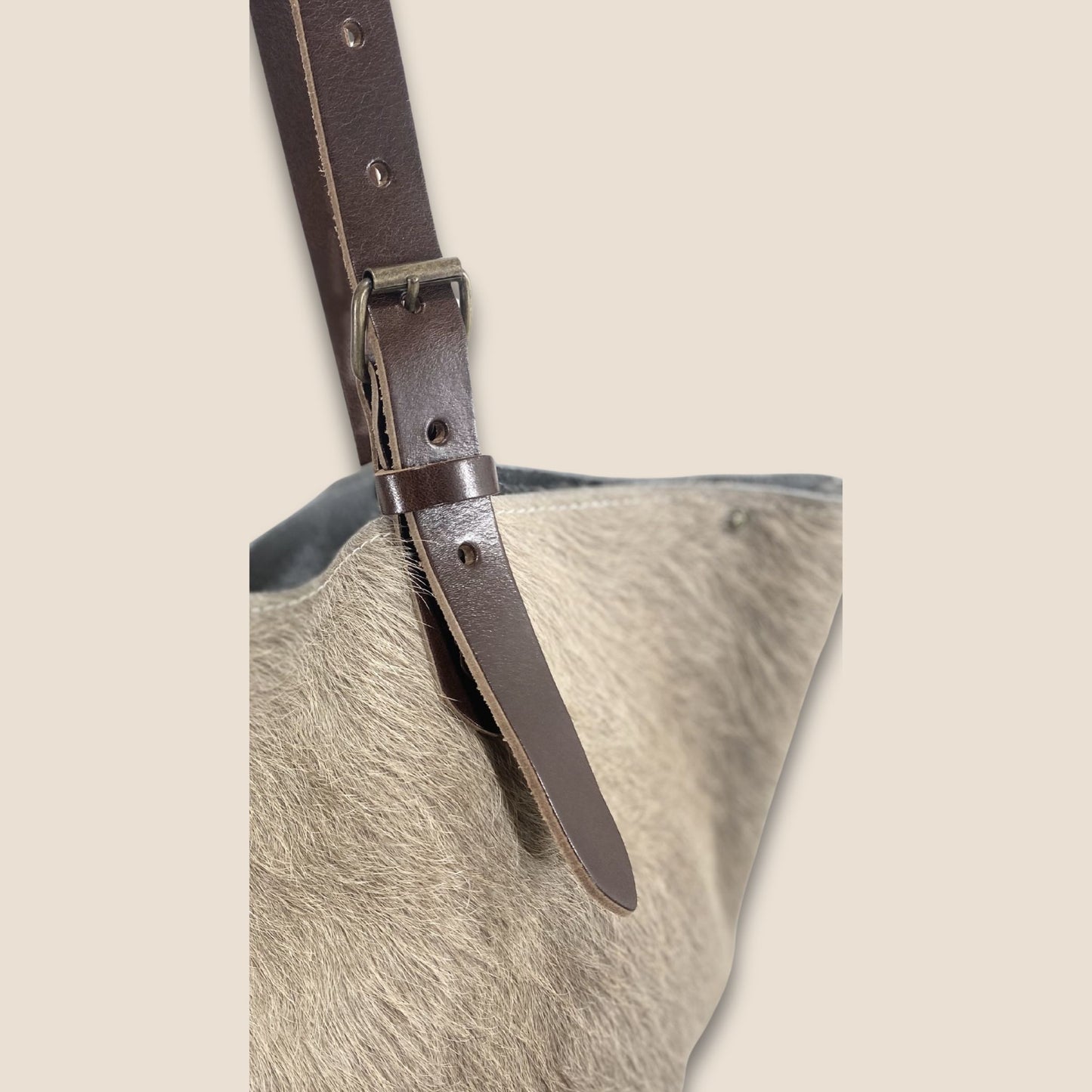 Gros plan sur la lanière réglable, la boucle et les rivets du cabas Brown Swiss #13/137.