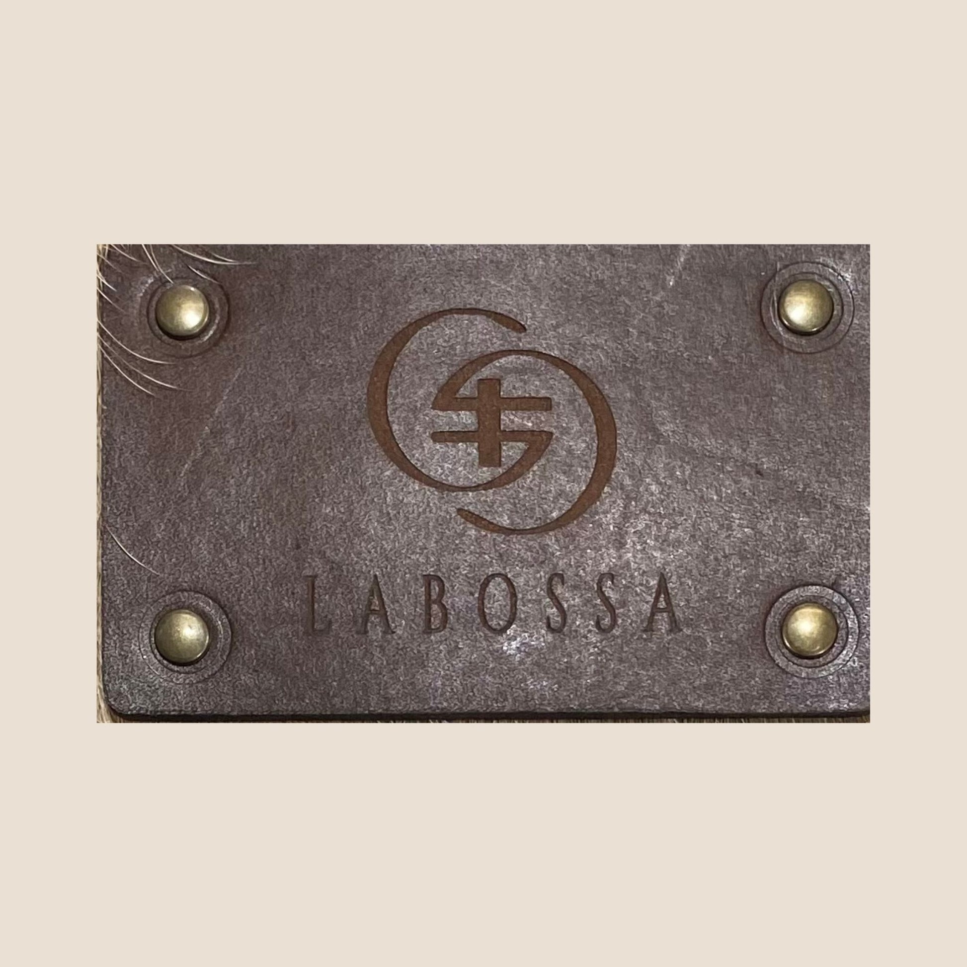 Gros plan sur la plaque extérieure en cuir portant le logo Labossa.