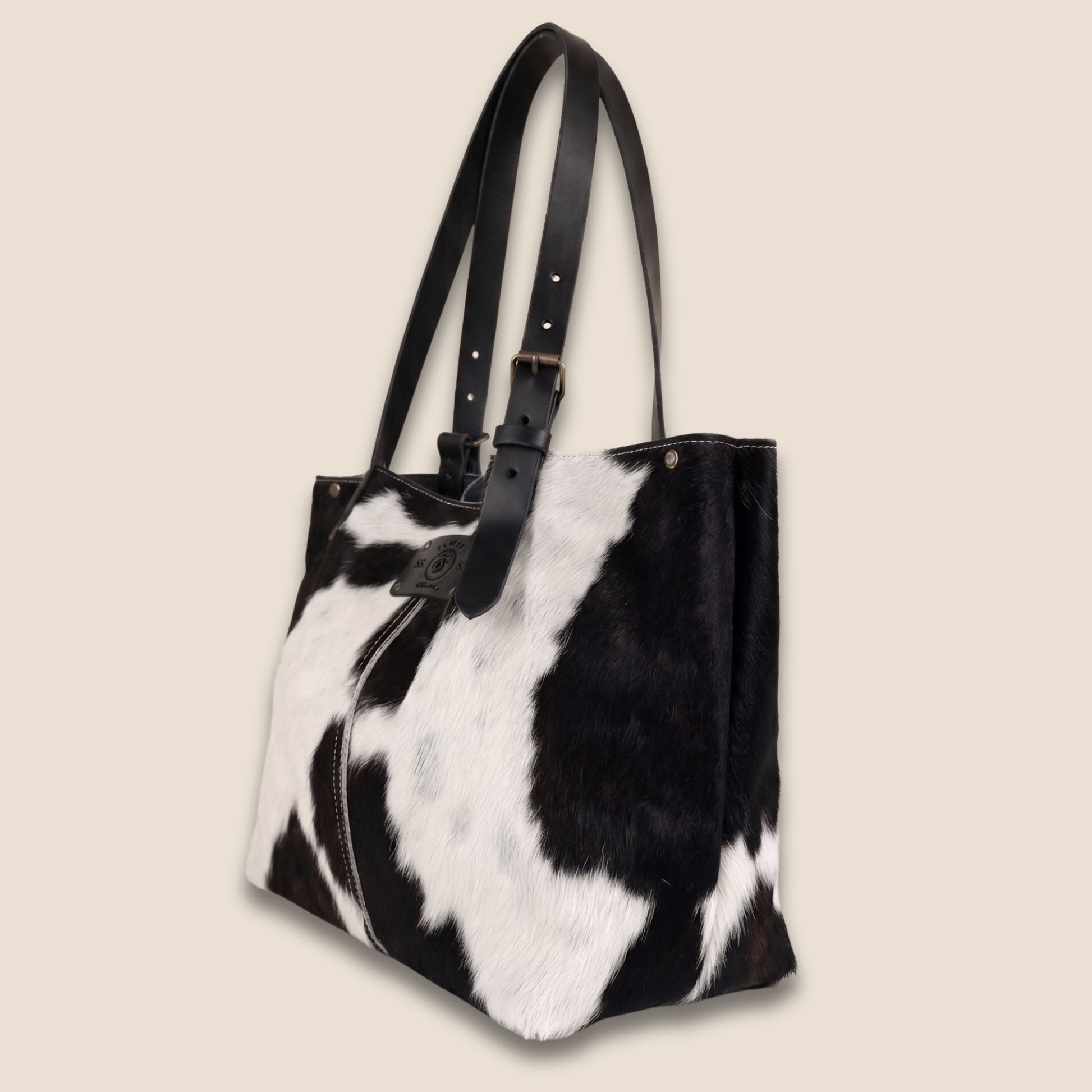 Cabas artisanal Holstein noir & blanc #13/128 – vue de profil – fond cuir noir