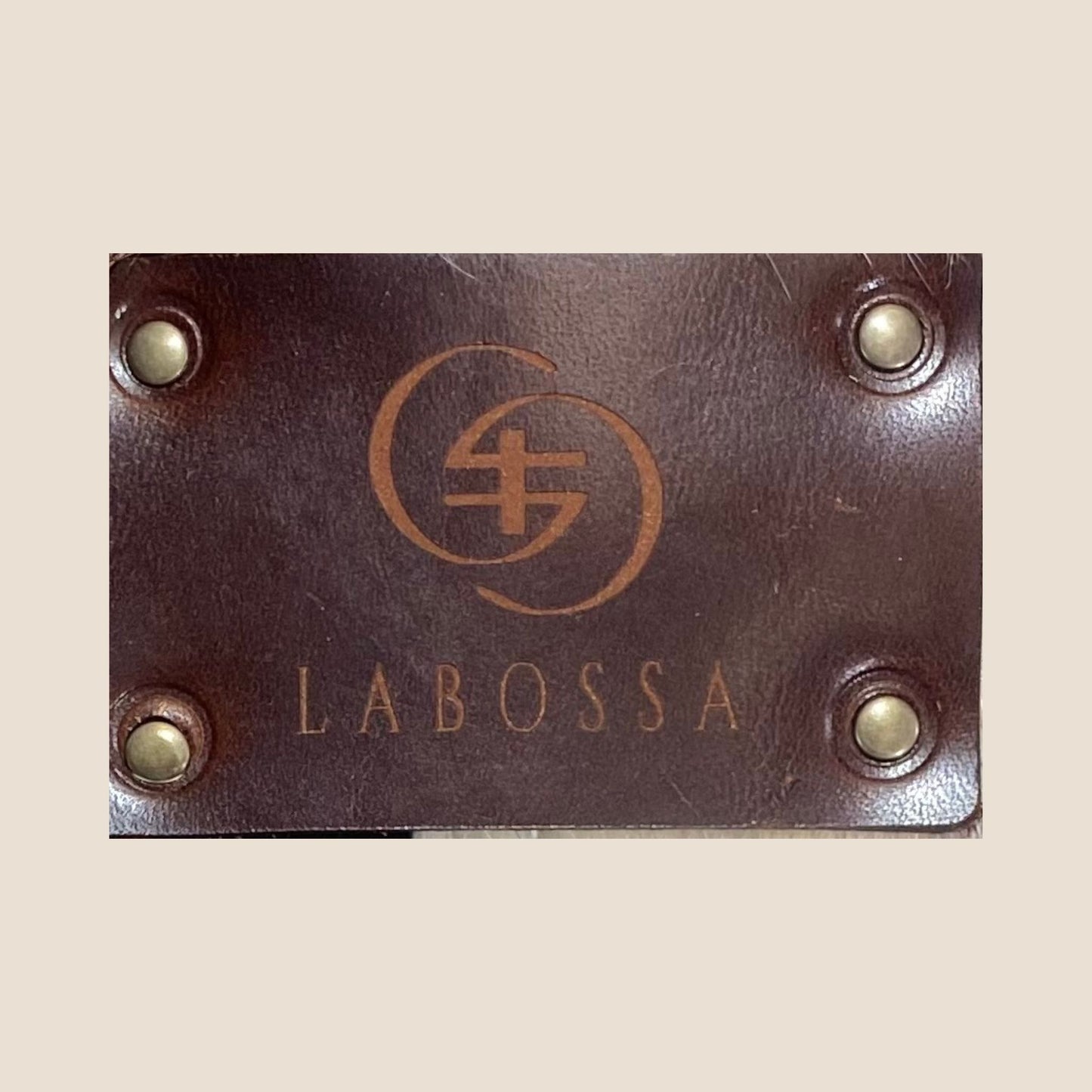 Gros plan sur la plaque extérieure en cuir marron portant le logo Labossa.