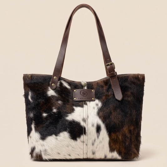 Cabas en peau de vache naturelle Normande 27/161, vue de face, robe blanche, brune et noire et lanières marron.