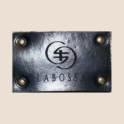 Patch extérieur noir Labossa fixé par quatre rivets sur le cabas en peau de vache Vosgienne.