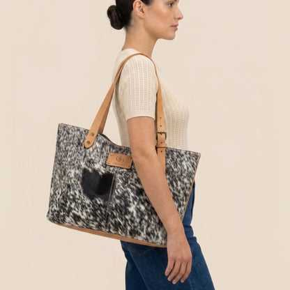 Cabas Vosgienne #13/149 porté à l’épaule par un modèle, avec ses lanières en cuir cognac.