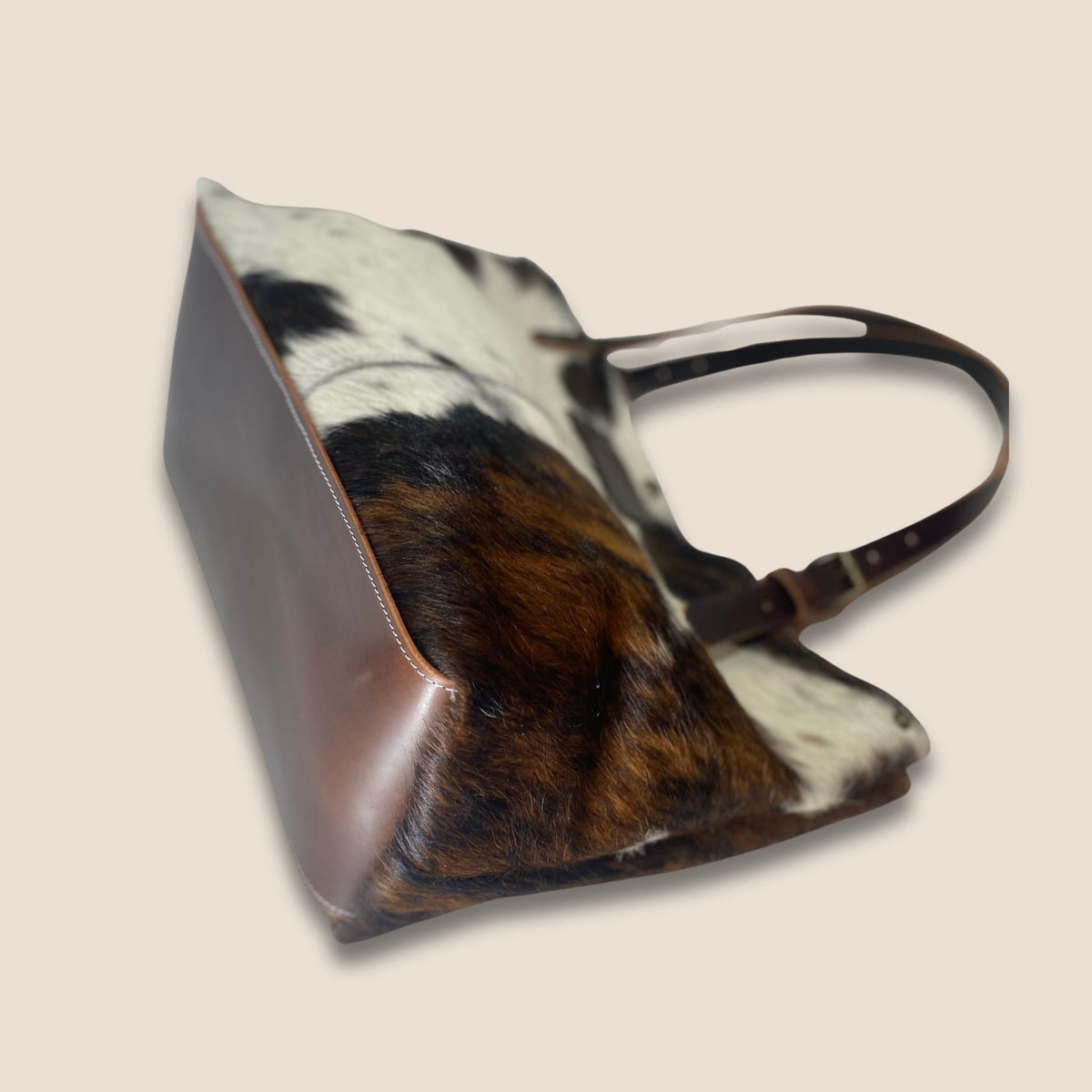 Dessous du cabas Normande n° 27/164, avec fond rectangulaire en cuir marron et coutures sur le pourtour.