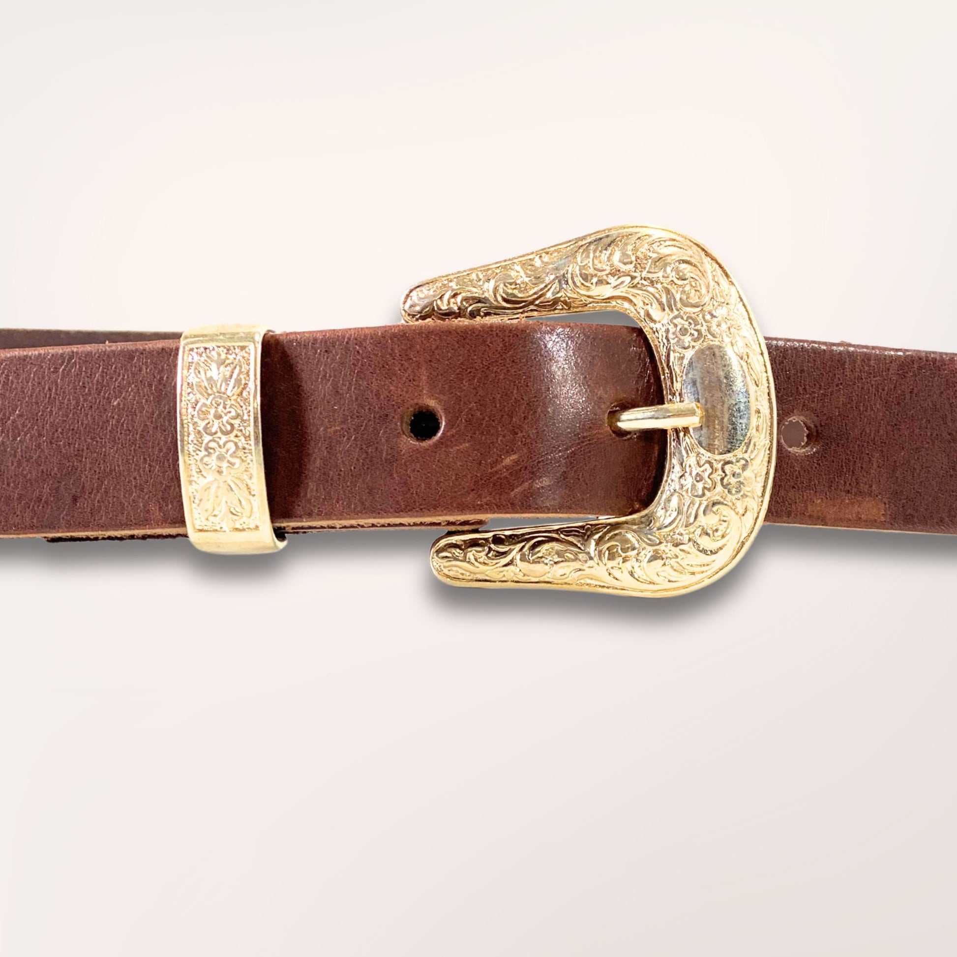 Détail de la boucle Arizona dorée et ciselée sur cuir de vachette marron foncé, maroquinerie artisanale de Roubaix.