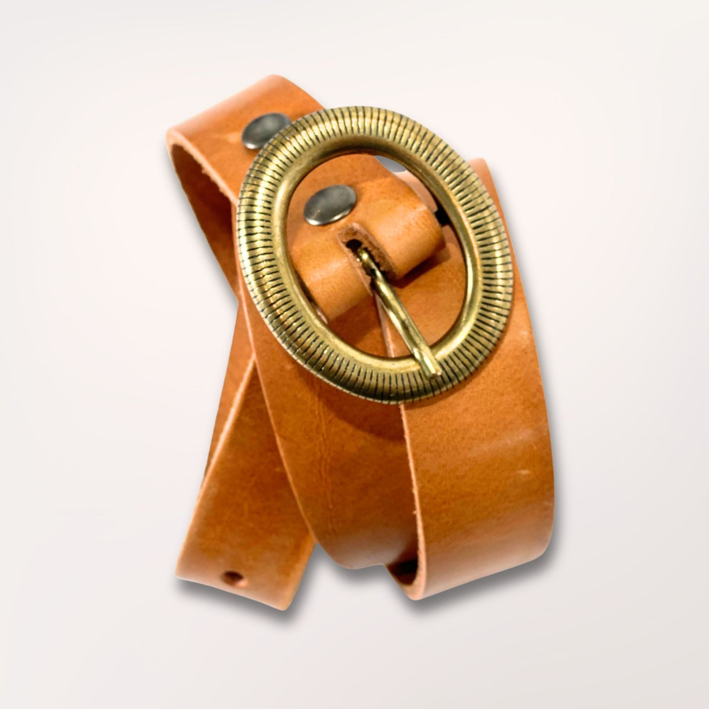 Ceinture artisanale naturelle enroulée montrant la souplesse et la qualité du cuir.