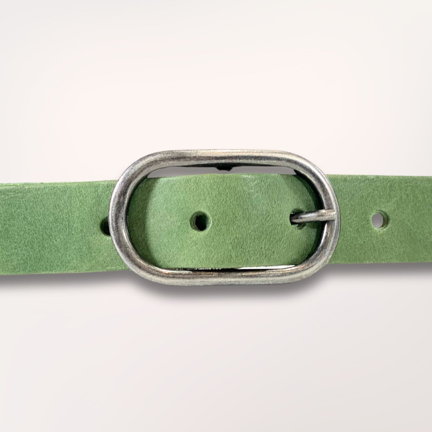Détail de la boucle argentée sur cuir vert séquoia, finitions à l'atelier de Roubaix.