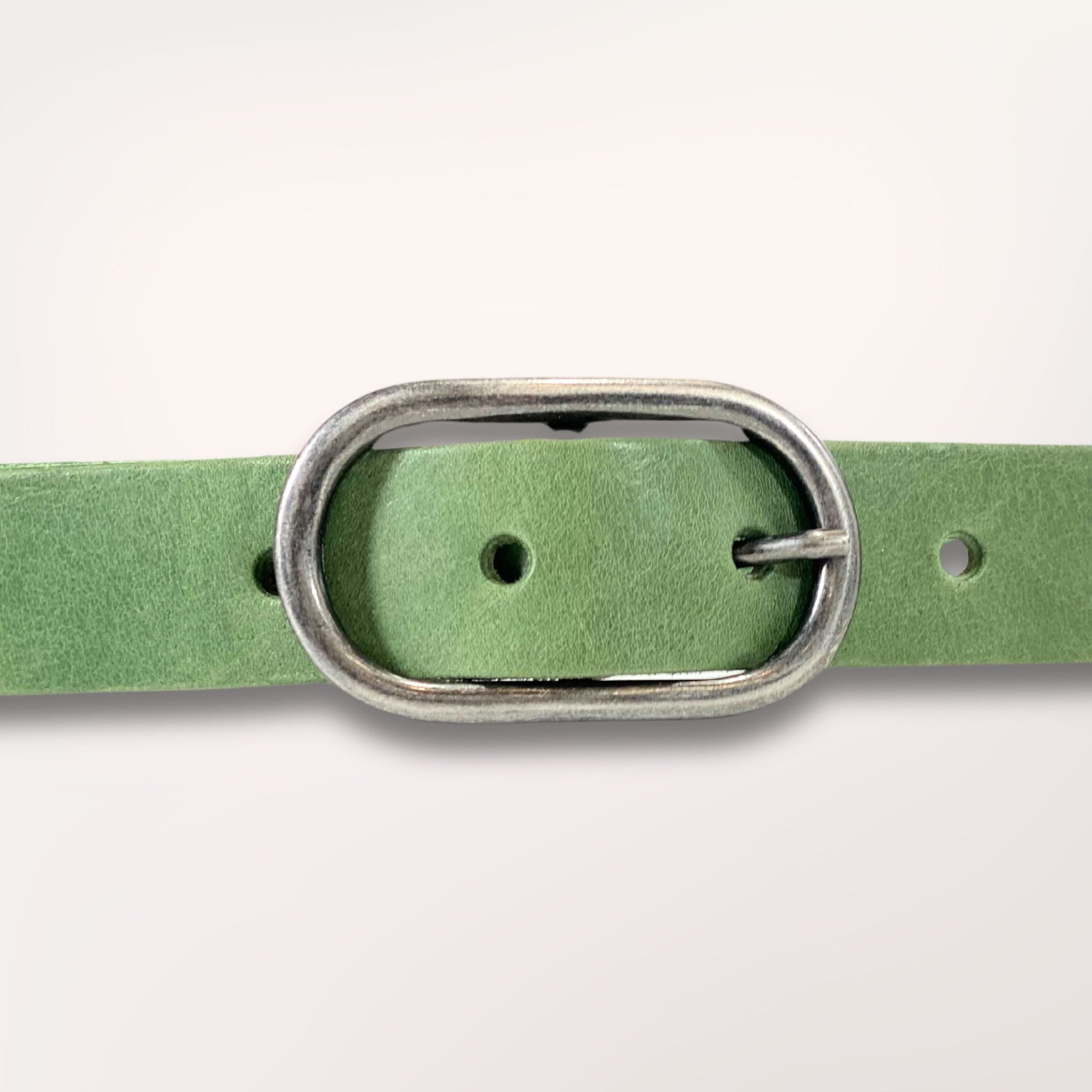 Détail de la boucle argentée sur cuir vert séquoia, finitions à l'atelier de Roubaix.