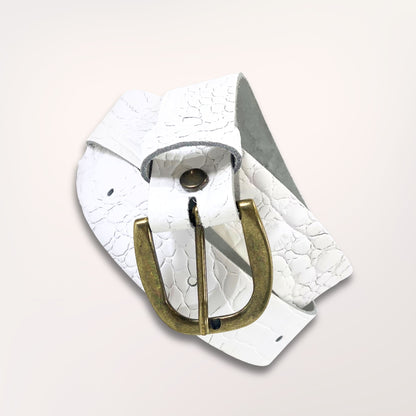 Ceinture artisanale blanche en cuir façon caïman enroulée, mettant en avant la souplesse du cuir et la qualité de la boucle dorée.