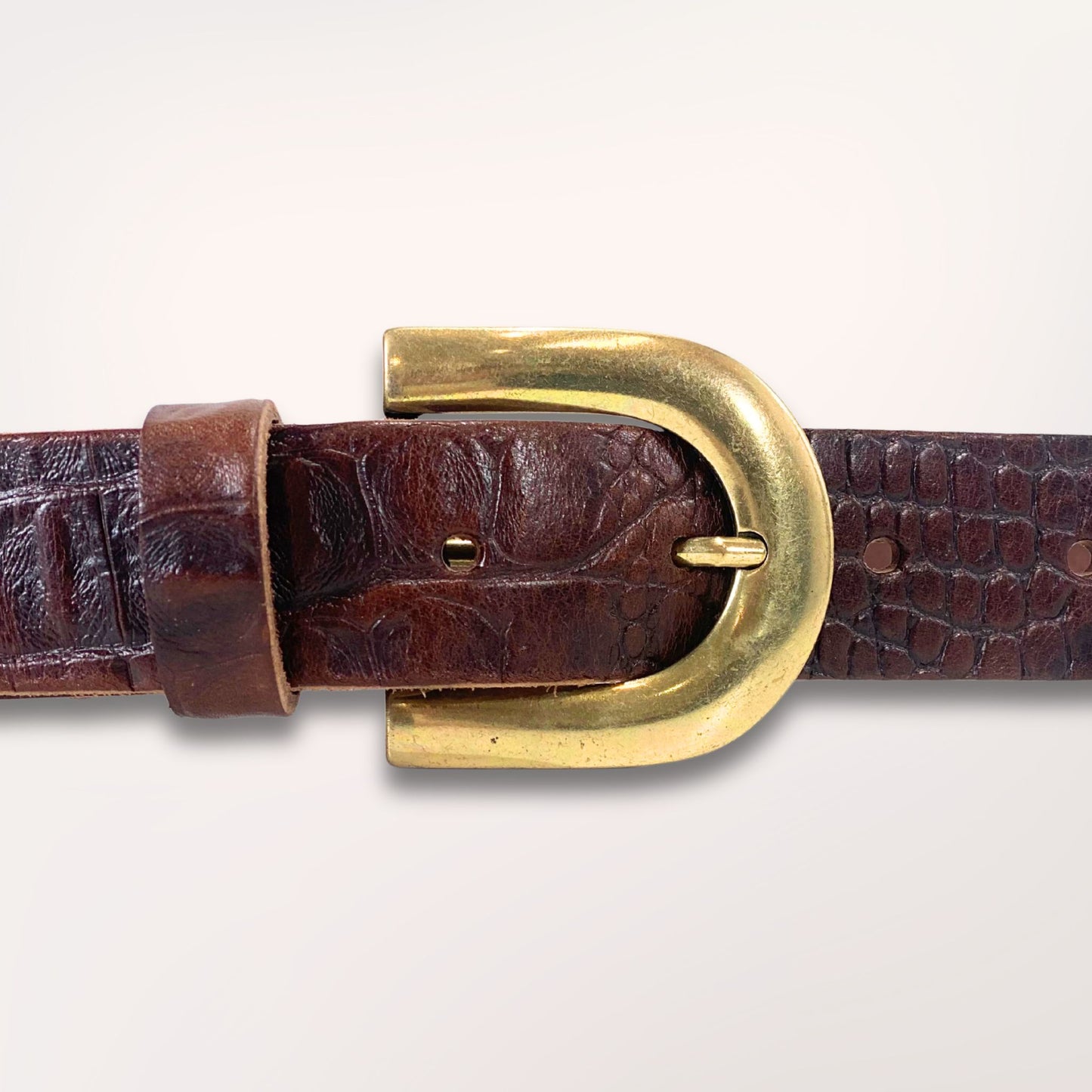 Gros plan sur la texture cuir marron chocolat embossé caïman et la boucle de la ceinture Primavera, finition artisanale Labossa.