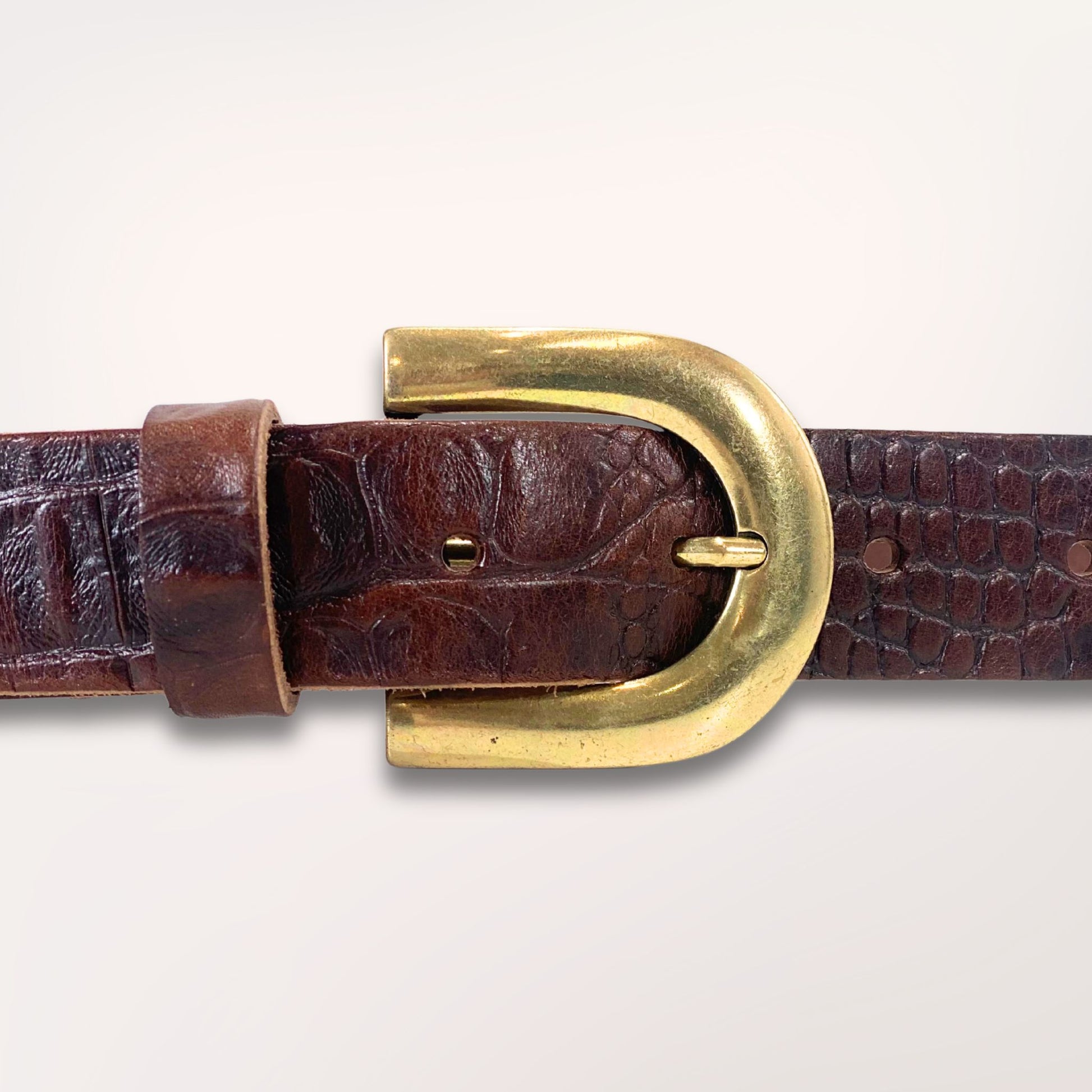 Gros plan sur la texture cuir marron chocolat embossé caïman et la boucle de la ceinture Primavera, finition artisanale Labossa.