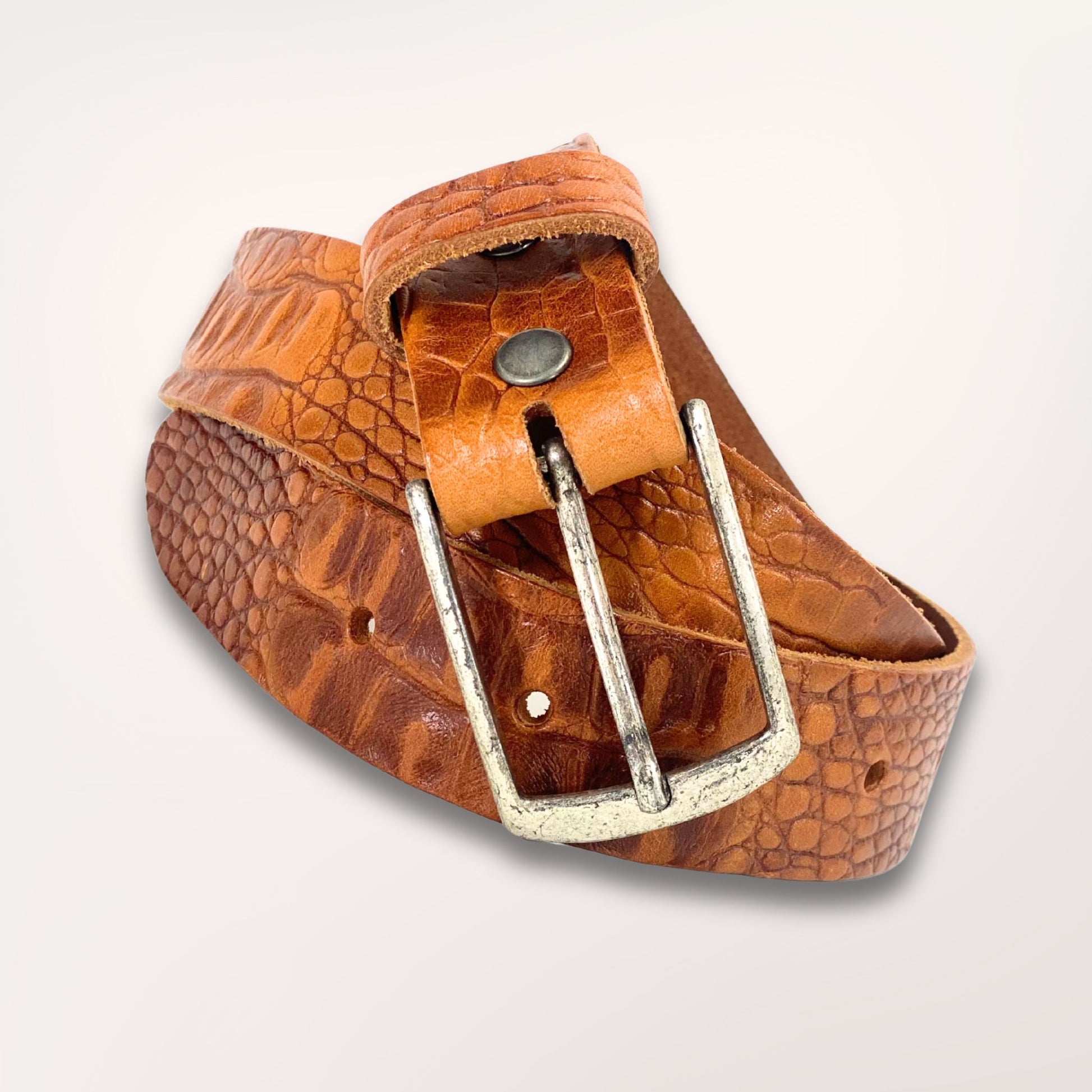 Ceinture artisanale cognac en cuir façon caïman enroulée, mettant en avant la qualité du cuir Labossa Atelier.