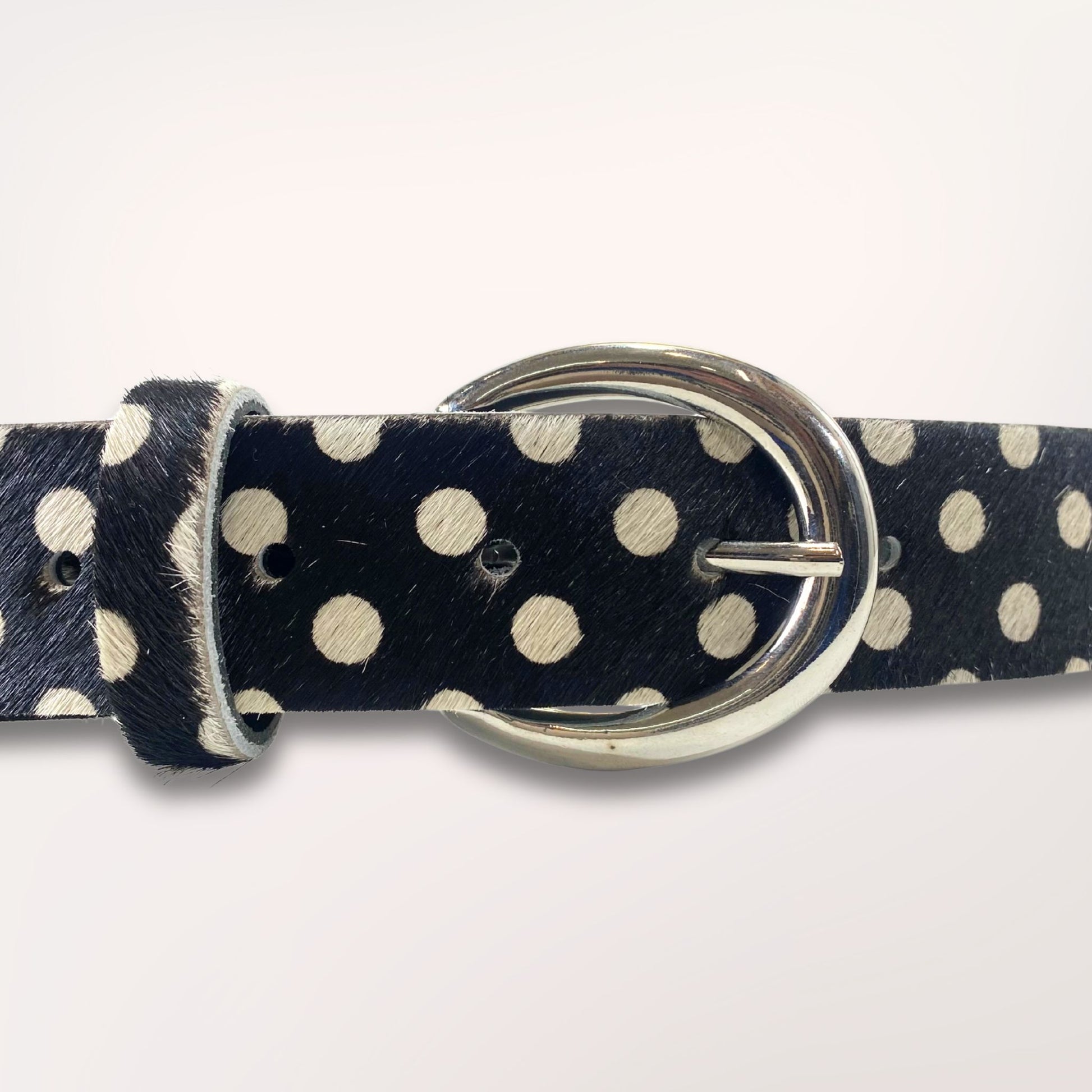 Gros plan sur la boucle argentée et le cuir poil de vache au motif pois de la ceinture Swing, maroquinerie faite main dans l'atelier Labossa à Roubaix.