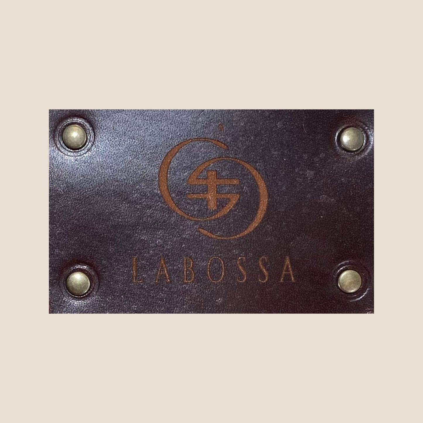 Gros plan sur la plaque extérieure en cuir marron portant le logo Labossa, fixée sur le cabas en peau de vache naturelle #13/147.