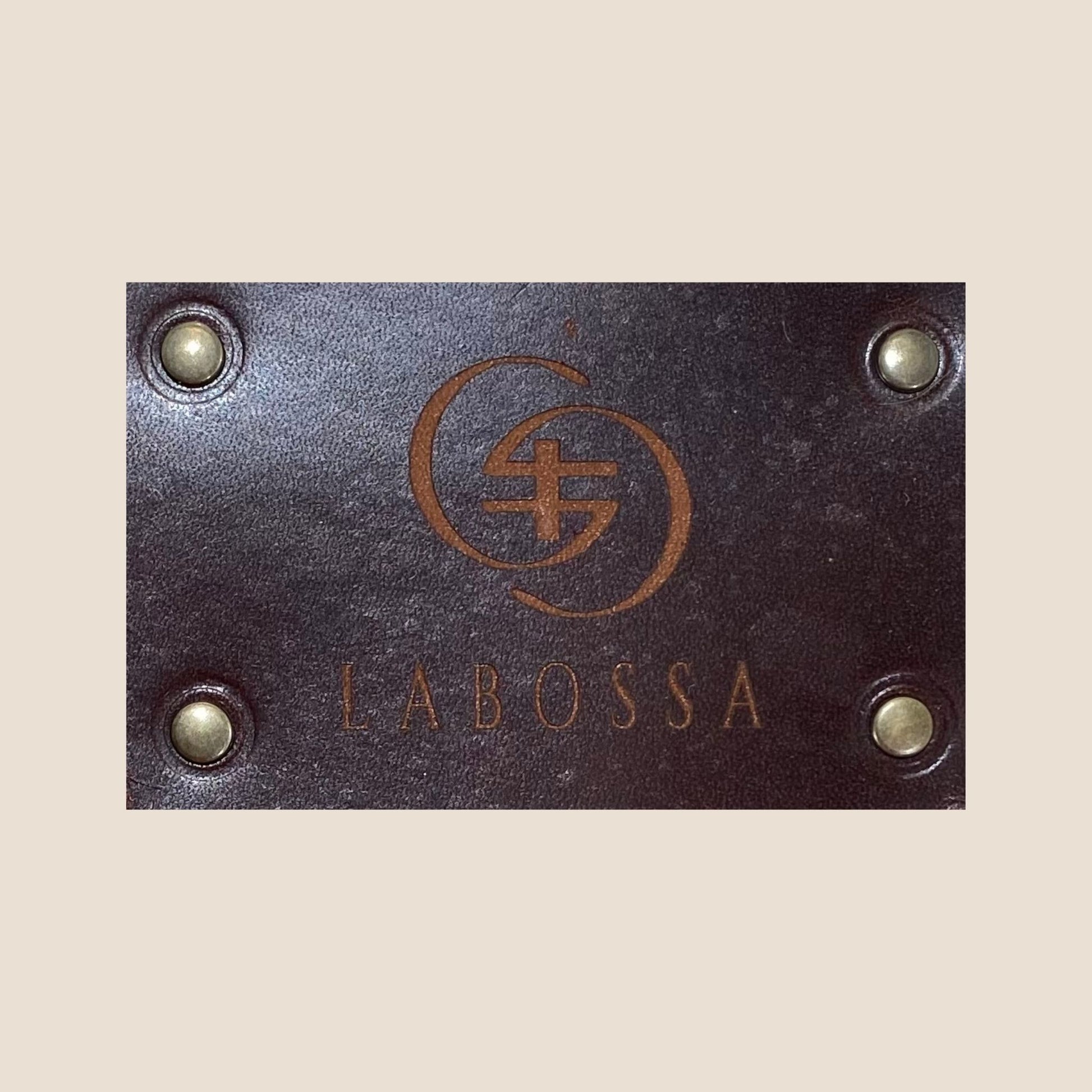 Gros plan sur la plaque extérieure en cuir marron portant le logo Labossa, fixée sur le cabas en peau de vache naturelle #13/147.