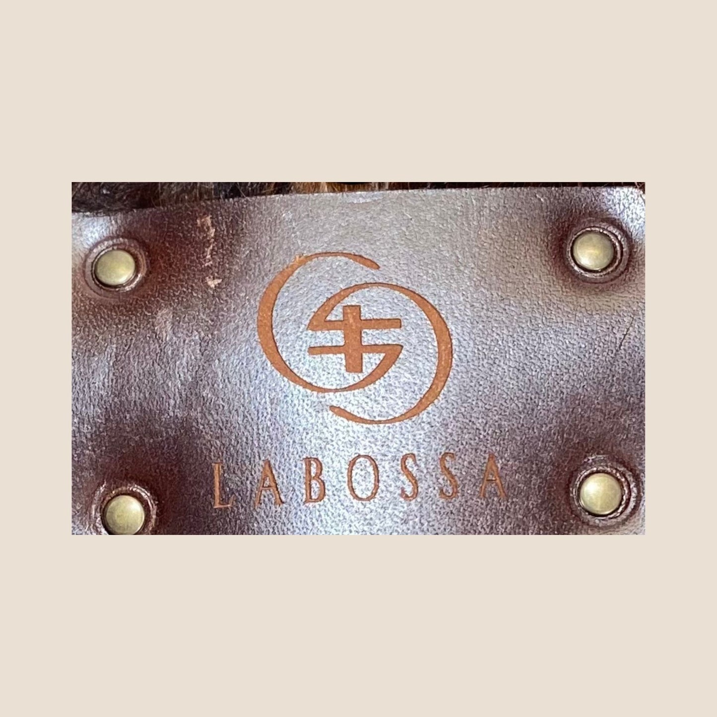 Gros plan sur la plaque extérieure en cuir marron portant le logo Labossa, fixée sur le cabas en peau de vache naturelle #13/146.